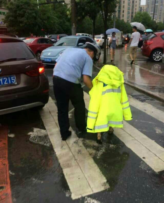 交警为迷路孩子披上自己的雨衣