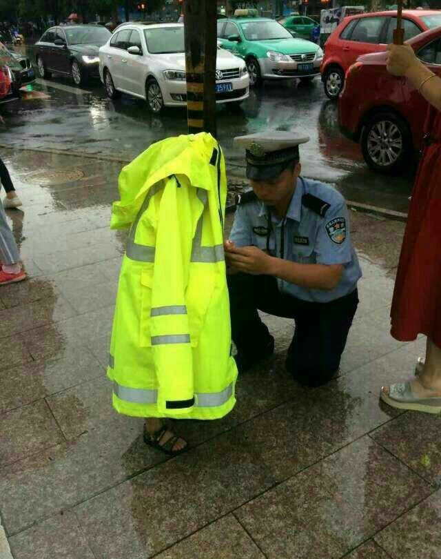 交警为迷路孩子披上自己的雨衣