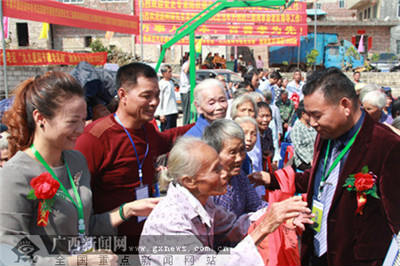 广西青武投资有限公司董事长农炳青给老人赠送慰问品慰问金。网络图