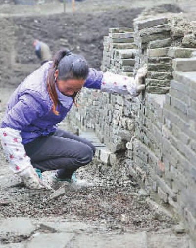 考古工作人员正细致清理泥土。