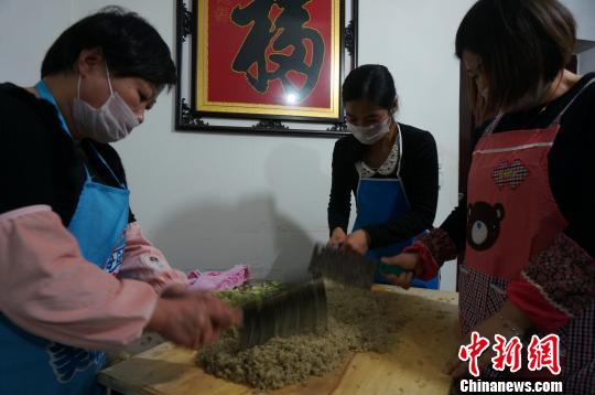 图为志愿者们在王孝利家准备饺子馅。　韩章云 摄