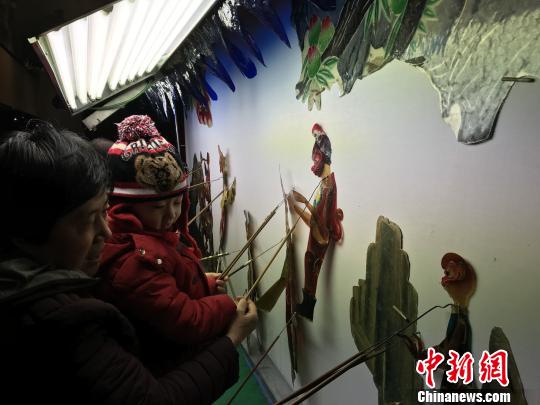 大人孩子体验北京皮影戏剧团的皮影戏 钟欣 摄