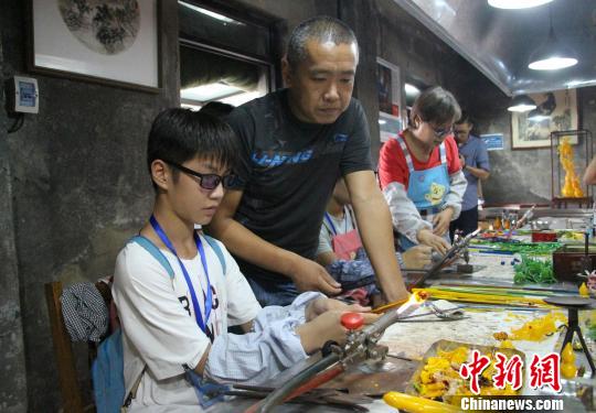 在中华琉璃文化创意园内，学生们在园区老师的指点下体验琉璃加工过程。　赵晓 摄