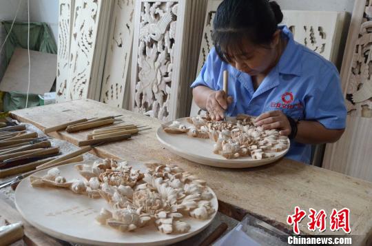 孙老家镇李家村41岁的雕刻师李燕正在雕刻一件由牡丹花和喜鹊组合而成的座屏据她介绍，她从10余岁开始学习木雕技艺，一件作品大约需要30天的时间才能完工。　孙婷婷 摄