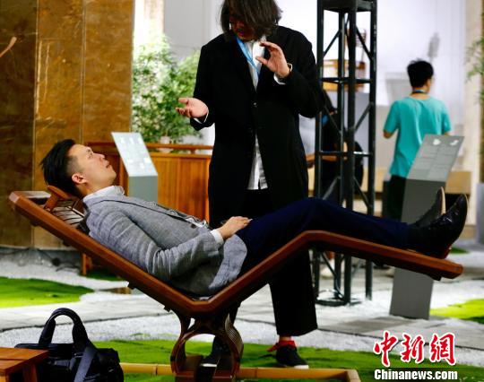 9月20日，曾获得德国红点设计奖的设计师石大宇在北京国际设计周设计博览会上带来他最新设计的竹椅系列。图为观众现场试展出作品“椅巴适”。(完) 富田 摄