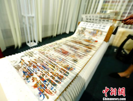 9月20日，多款新颖设计品亮相在北京国际设计周设计博览会。图为展出的龙鳞装佛典巨作《三十二篆金刚经》，展开接续总长达73.4米。(完) 富田 摄