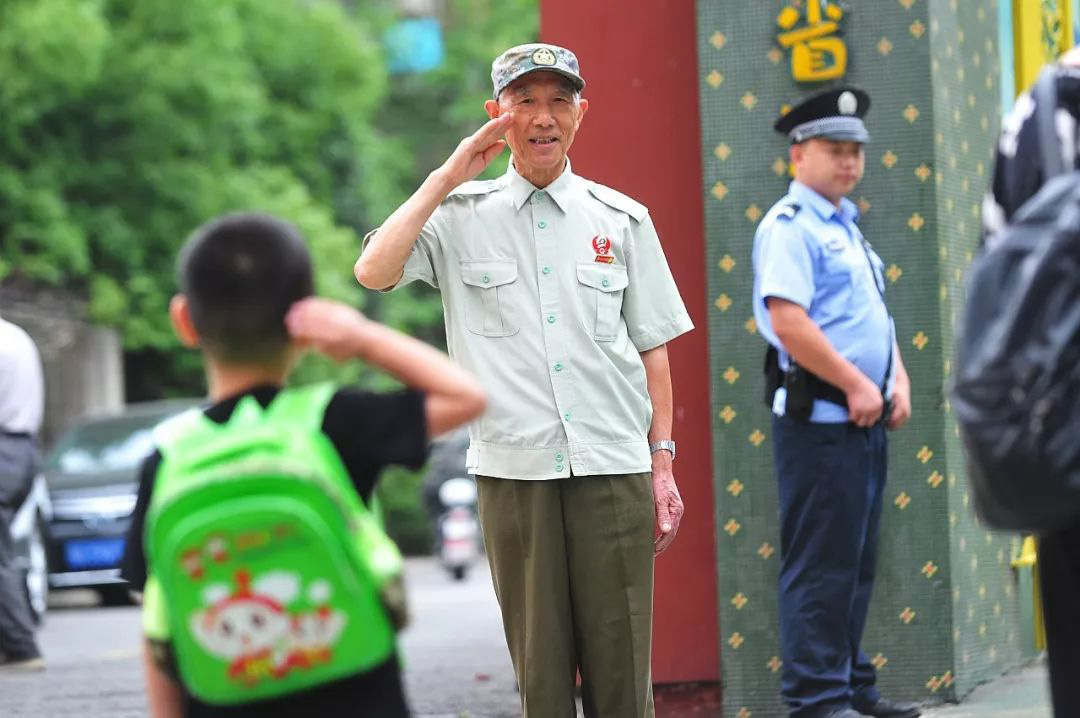 79岁的李国发给入园的孩子敬礼  记者彭年 摄