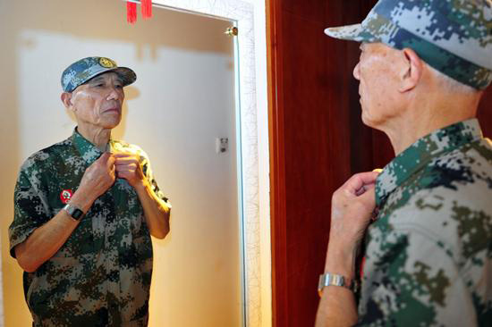 79岁的李国发一年四季都是军装在身，每次出门前都会整理军容。记者 彭年 摄