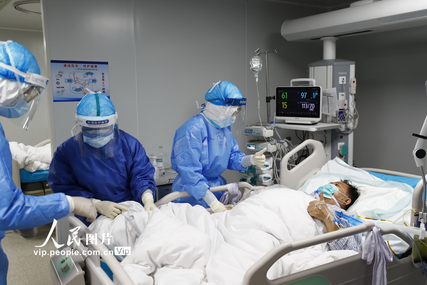 2020年2月24日，火神山医院重症一科医护人员正在检查患者身体状况，并和患者相互点赞加油！