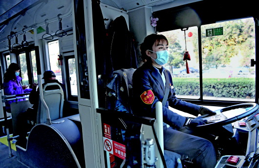 12月18日，黄菲驾驶公交车行驶在路上。新华社记者李安摄