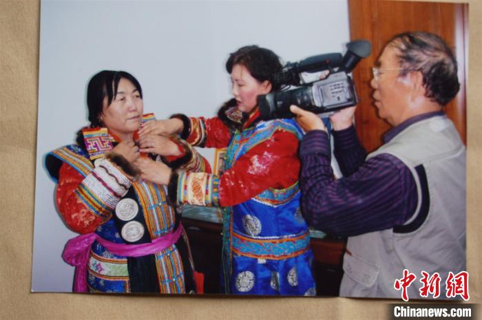 图为郭雨桥(右一)用摄像机记录蒙古族生活。本人供图