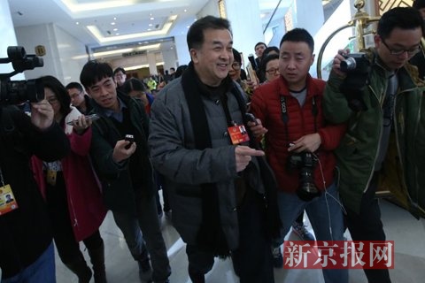 黄宏亮相北京会议中心大厅，在走向餐厅的路上被媒体包围。新京报记者 王贵彬 摄