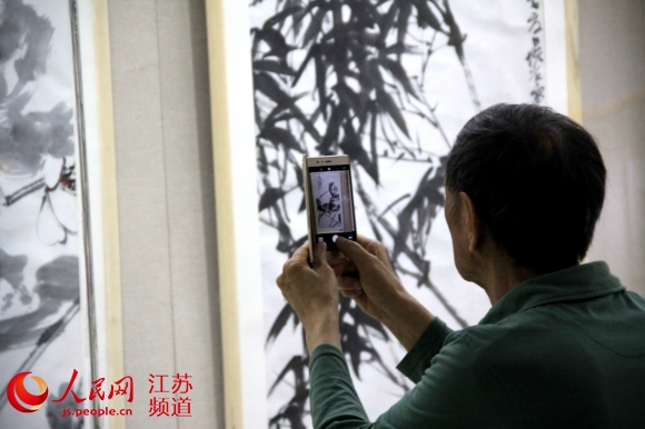 图为参加活动的嘉宾参观齐白石美术馆举办的书画展。