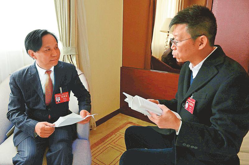 　1月30日，南充代表团吴永阳代表（右）与胡先成代表交流履职心得。