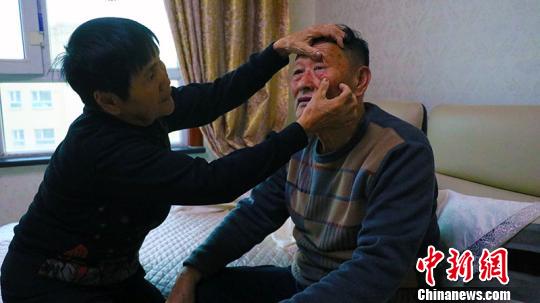2018年，10月底夏忠惠老伴张胜利做完眼睛手术，夏忠惠帮助老伴查看眼睛。　王小军 摄