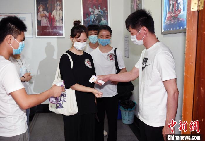 福建省实验闽剧院工作人员对参加选拔活动的青年戏曲演员进行体温检测。　记者刘可耕 摄