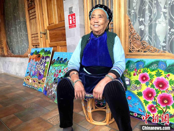 图为“农民画家”王秉秀坐在她的油画作品前。　缪超 摄